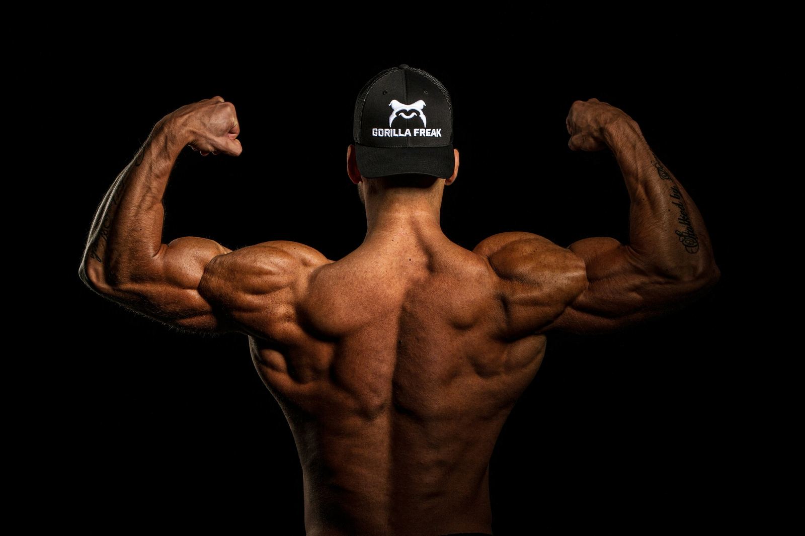 Muscular back flexing biceps, hypertrophy training
